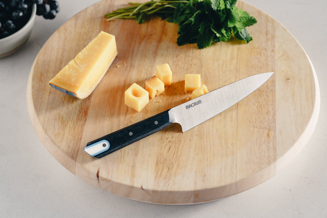 139 mm Fremont Utility on a round wooden board with cheese and herbs